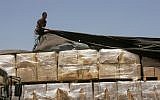 A Palestinian checks a truck loaded with humanitarian aid from the US as it arrives in the Palestinian town of Rafah through the Kerem Shalom crossing between Israel and the southern Gaza Strip on August 6, 2014.