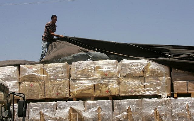 A Palestinian checks a truck loaded with humanitarian aid from the US as it arrives in the Palestinian town of Rafah through the Kerem Shalom crossing between Israel and the southern Gaza Strip on August 6, 2014. A Palestinian checks a truck loaded with humanitarian aid from the US as it arrives in the Palestinian town of Rafah through the Kerem Shalom crossing between Israel and the southern Gaza Strip on August 6, 2014.