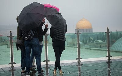 File: Tourists look out over Jerusalem's Old City, as seen from the rooftop of the Austrian hospice, on a foggy winter day, January 2, 2018. (Miriam Alster/Flash90)