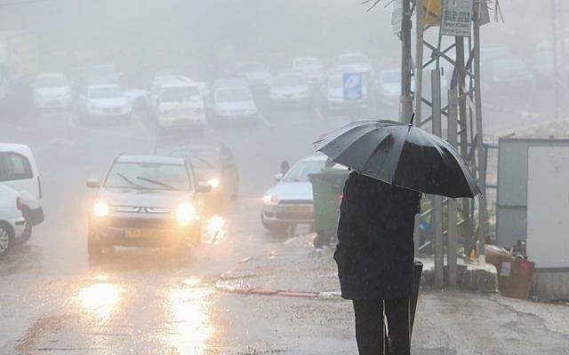 People hold umbrellas to protect themselves from the rain as they walk in the northern Israeli city of Tzfat on January 5, 2018, as heavy rain and a wind storm hit Israel. ( David Cohen/Flash90) People hold umbrellas to protect themselves from the rain as they walk in the northern Israeli city of Tzfat on January 5, 2018, as heavy rain and a wind storm hit Israel. ( David Cohen/Flash90)