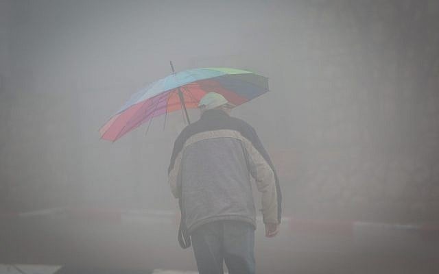 People hold umbrellas to protect themselves from the rain as they walk in the northern Israeli city of Safed on January 18, 2018, as heavy rains and winds hit Israel. (David Cohen/Flash90) People hold umbrellas to protect themselves from the rain as they walk in the northern Israeli city of Safed on January 18, 2018, as heavy rains and winds hit Israel. (David Cohen/Flash90)