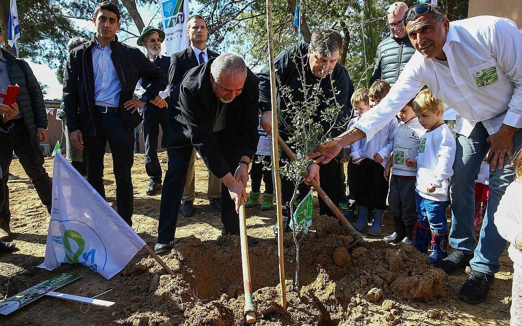 Avigdor Liberman (c)  plants a tree  for the Jewish holiday of Tu Bishvat in Kibbutz Kfar Aza, in southern Israel, January 31, 2018. (Flash90)