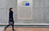 A woman walks past a placard with the words European Parliament inscribed in several languages of the European Union member states outside the Espace Leopold on February 25, 2016 in Brussels, Belgium. (Ben Pruchnie/Getty Images via JTA)