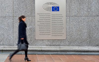 A woman walks past a placard with the words European Parliament inscribed in several languages of the European Union member states outside the Espace Leopold on February 25, 2016 in Brussels, Belgium. (Ben Pruchnie/Getty Images via JTA)