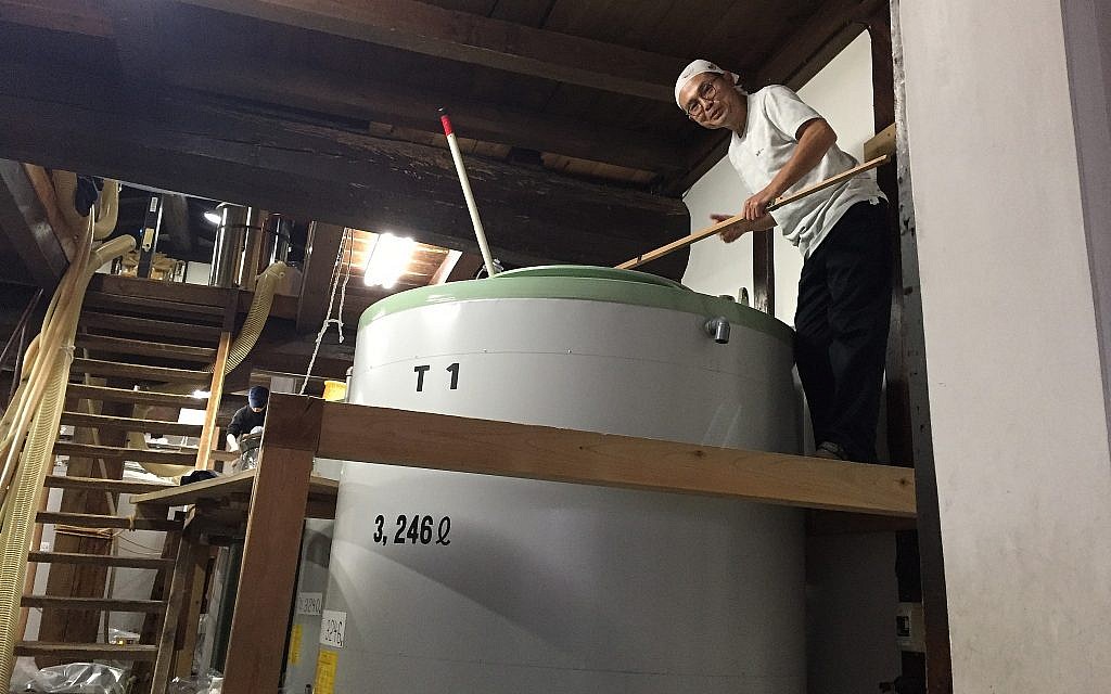 A master sake brewer of Funasaka Sake Brewery atop his tank at a kosher sake brewery in Takayam, Japan, November 2017. Amanda Borschel-Dan/Times of Israel)