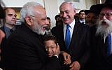 Indian Prime Minister, left, embracing 11-year-old Moshe Holtzberg, whose Chabad emissary parents were killed in a 2008 terror attack in Mumbai, with Prime Minister Benjamin Netanyahu on left in Israel, July 5, 2017 . (Haim Zach/Israeli Government Press Office)