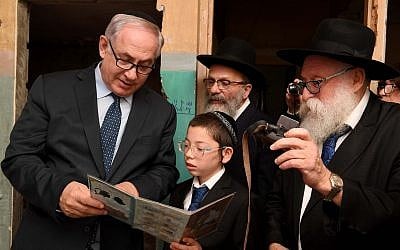 Prime Minister Benjamin Netanyahu meets with Moshe Holtzberg, the son of Rabbi Gavriel and Rivky Holtzberg, who were killed in the November 26, 2008, terror attack in Mumbai, during a memorial for the victims of the attack at Nariman Chabad House in Mumbai on January 18, 2018. (GPO)
