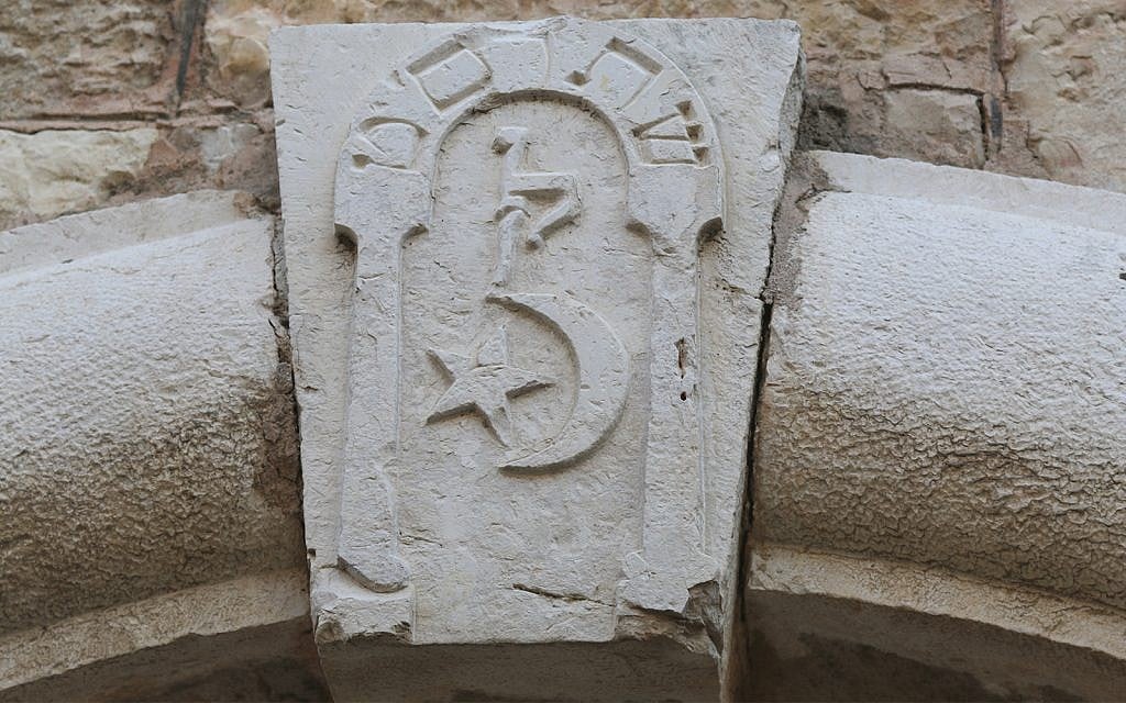 A keystone above the entrance to 14 Hafetz Hayim street in Jerusalem, dating to the early 20th century, with pro-Turkish symbols. (Shmuel Bar-Am)