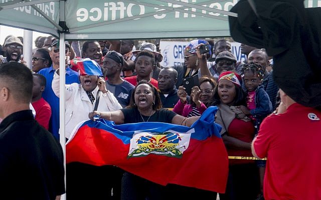 Haitians line the sidewalks as President Donald Trump's motorcade returns to Mar-a-Lago in West Palm Beach, Florida, on January 15, 2018. (AP Photo/Andrew Harnik) Haitians line the sidewalks as President Donald Trump's motorcade returns to Mar-a-Lago in West Palm Beach, Florida, on January 15, 2018. (AP Photo/Andrew Harnik)