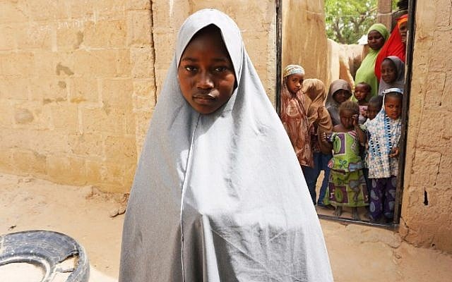 Hassana Mohammed, 13, who scaled a fence to escape an attack on her Government Girls Science and Technical College, stands outside her home in Dapchi, Nigeria, on February 22, 2018. (AFP PHOTO / AMINU ABUBAKAR) Hassana Mohammed, 13, who scaled a fence to escape an attack on her Government Girls Science and Technical College, stands outside her home in Dapchi, Nigeria, on February 22, 2018. (AFP PHOTO / AMINU ABUBAKAR)