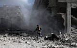 A civil defense volunteer, known as the White Helmets, checks the site of a regime air strike in the rebel-held town of Saqba, in the besieged Eastern Ghouta region on the outskirts of the capital Damascus, on February 23, 2018. (AFP PHOTO / ABDULMONAM EASSA)