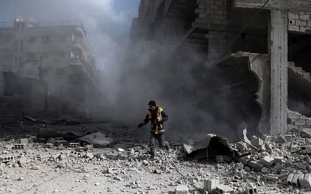 A civil defense volunteer, known as the White Helmets, checks the site of a regime air strike in the rebel-held town of Saqba, in the besieged Eastern Ghouta region on the outskirts of the capital Damascus, on February 23, 2018. (AFP PHOTO / ABDULMONAM EASSA) A civil defense volunteer, known as the White Helmets, checks the site of a regime air strike in the rebel-held town of Saqba, in the besieged Eastern Ghouta region on the outskirts of the capital Damascus, on February 23, 2018. (AFP PHOTO / ABDULMONAM EASSA)