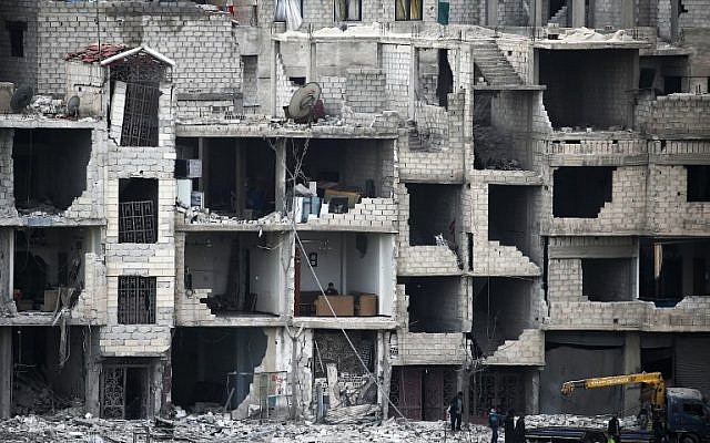Syrians walk past destroyed buildings in Arbin in the rebel-held enclave of Eastern Ghouta on February 25, 2018. (AFP Photo/Abdulmonam Eassa) Syrians walk past destroyed buildings in Arbin in the rebel-held enclave of Eastern Ghouta on February 25, 2018. (AFP Photo/Abdulmonam Eassa)