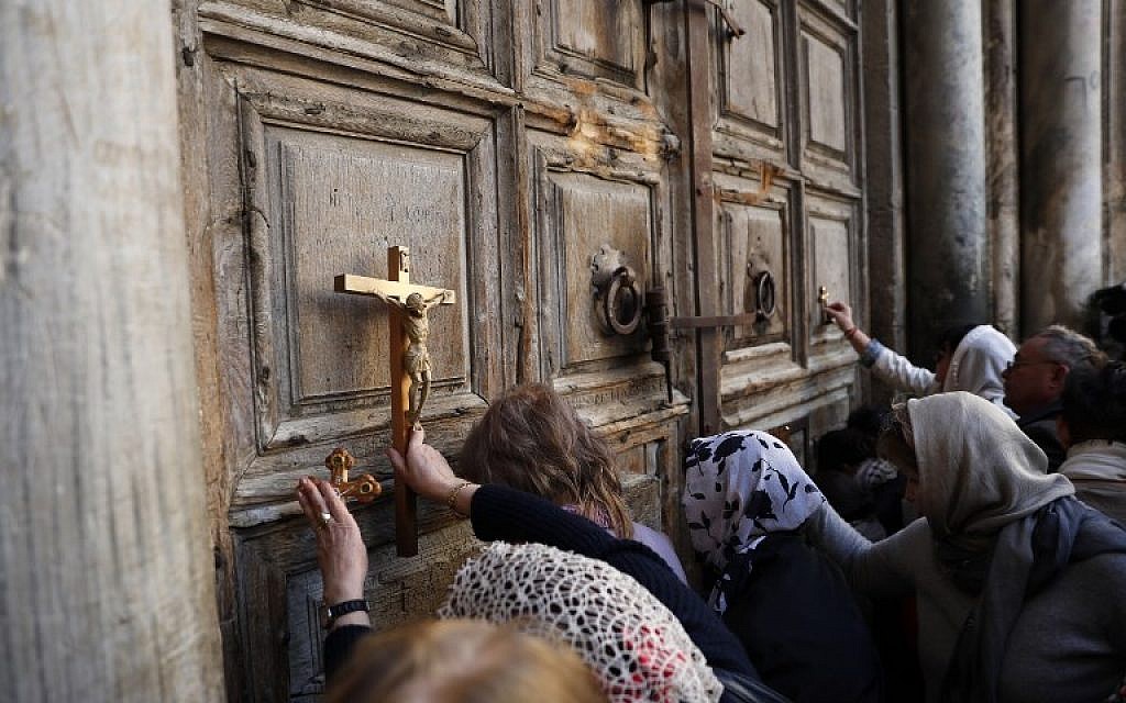 Pilgrims pray outside the closed gate of the Church of the Holy Sepulchre in Jerusalem's Old City on February 27, 2018.(AFP PHOTO / Thomas COEX)