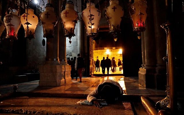 A Christian worshiper prays on the anointing stone inside the Church of the Holy Sepulchre after it reopened on February 28, 2018 following a three-day closure to protest against Israeli tax measures and a proposed law. (AFP/ Thomas COEX) A Christian worshiper prays on the anointing stone inside the Church of the Holy Sepulchre after it reopened on February 28, 2018 following a three-day closure to protest against Israeli tax measures and a proposed law. (AFP/ Thomas COEX)