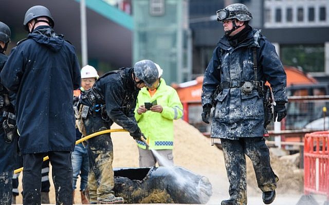 Bomb disposal expert Adam Roberts (R) walks past as a colleague from the explosive ordinance disposal unit hoses down a defused US-made bomb dropped during World War II a day after it was discovered on a harborfront construction site in the Wan Chai district of Hong Kong on February 1, 2018.
(Anthony Wallace/AFP) Bomb disposal expert Adam Roberts (R) walks past as a colleague from the explosive ordinance disposal unit hoses down a defused US-made bomb dropped during World War II a day after it was discovered on a harborfront construction site in the Wan Chai district of Hong Kong on February 1, 2018.
(Anthony Wallace/AFP)
