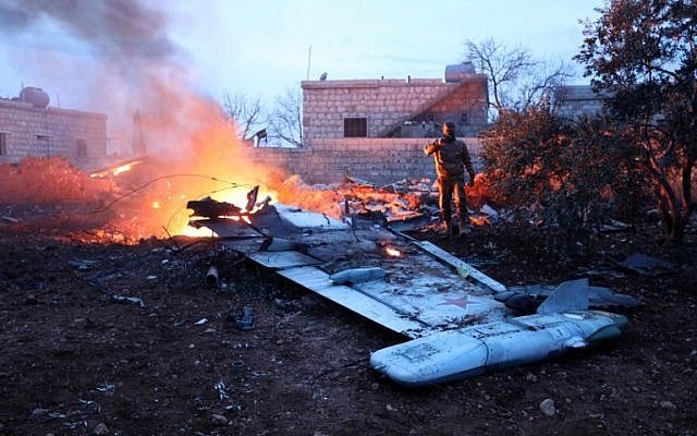 A picture taken on February 3, 2018, shows a Rebel fighter taking a picture of a downed Sukhoi-25 fighter jet in Syria's northwest province of Idlib. (AFP photo) A picture taken on February 3, 2018, shows a Rebel fighter taking a picture of a downed Sukhoi-25 fighter jet in Syria's northwest province of Idlib. (AFP photo)