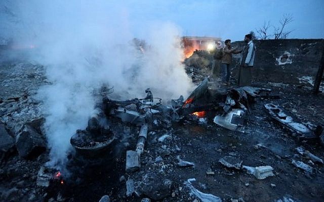 A picture taken on February 3, 2018, shows Syrian men standing at the site of a downed Sukhoi-25 fighter jet in the Syrian city of Saraqib, southwest of Aleppo. (AFP PHOTO / OMAR HAJ KADOUR) A picture taken on February 3, 2018, shows Syrian men standing at the site of a downed Sukhoi-25 fighter jet in the Syrian city of Saraqib, southwest of Aleppo. (AFP PHOTO / OMAR HAJ KADOUR)
