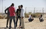 Detained African migrants standing outside the Holot detention center, located in Israel's southern Negev desert near the Egyptian border, February 4, 2018. (MENAHEM KAHANA/AFP)