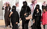 A picture taken on January 19, 2018 shows Saudi women clad in the Abaya robes and men walking during the King Abdulaziz Camel Festival in Rumah, some 160 kilometers east of Riyadh. (AFP Photo/Fayez Nureldine)