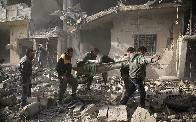 Members of Syrian civil defence forces known as White Helmets evacuate a victim of an air strike in the rebel-held enclave of Arbin in the Eastern Ghouta near Damascus on February 8, 2018. (Amer ALMOHIBANY/AFP) Members of Syrian civil defence forces known as White Helmets evacuate a victim of an air strike in the rebel-held enclave of Arbin in the Eastern Ghouta near Damascus on February 8, 2018. (Amer ALMOHIBANY/AFP)