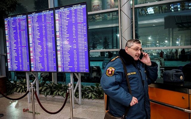 A Russian emergency employee stands next to flowers, in tribute to a plane crash victims, placed under of the flight schedule timetables at the Domodedovo International Airport, outside Moscow, February 11, 2018. (Maxim ZMEYEV/AFP) A Russian emergency employee stands next to flowers, in tribute to a plane crash victims, placed under of the flight schedule timetables at the Domodedovo International Airport, outside Moscow, February 11, 2018. (Maxim ZMEYEV/AFP)