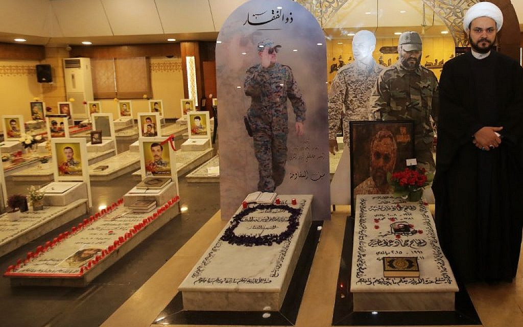 Secretary General of Shitte Iraqi Al-Nujabaa movement Akram al-Kaabi poses for a picture by  the tombs of slain Hezbollah military leaders Imad Moghnieh (R) and Moustapha Badreddine (L) in Beirut's southern suburb on February 13, 2018. (AFP PHOTO / ANWAR AMRO)