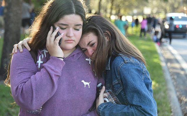 Students react following a shooting at Marjory Stoneman Douglas High School in Parkland, Florida, a city about 50 miles (80 kilometers) north of Miami on February 14, 2018.(AFP PHOTO / Michele Eve Sandberg) Students react following a shooting at Marjory Stoneman Douglas High School in Parkland, Florida, a city about 50 miles (80 kilometers) north of Miami on February 14, 2018.(AFP PHOTO / Michele Eve Sandberg)