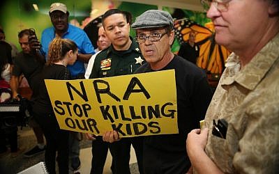 People protest against the National Rifle Association at the Broward County Court House, during the first appearance in court via video link for high school shooter Nikolas Cruz, on February 15, 2018, in Fort Lauderdale, Florida. (AFP Photo/Pool/Charles Trainor/Miami Herald)
