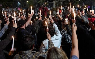 People hold up candles during a vigil put together by the Route 91 Foundation at the Las Vegas Community Healing Garden for victims of Wednesday's shooting at Marjory Stoneman Douglas High School in Parkland, Florida on February 16, 2018 in Las Vegas, Nevada. (Ethan Miller/Getty Images/AFP)