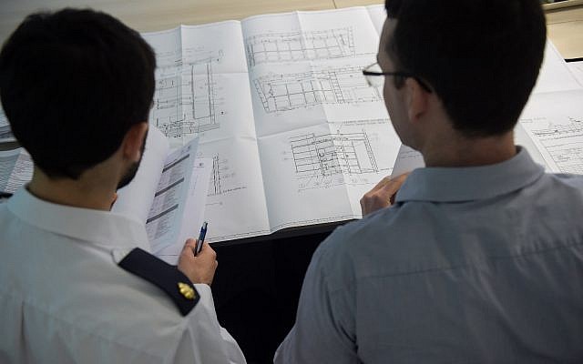 An Israeli Navy officer and German engineer look over plans for a Sa'ar 6 corvette that is under construction for the Israeli Navy in Kiel, Germany, in an undated photograph. (Israel Defense Forces)