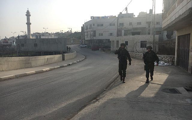Illustrative. Israeli troops walk through the Palestinian town of Halhul, north of Hebron, after a resident stabbed a security guard in a terror attack at a nearby settlement on February 7, 2018. (Israel Defense Forces) Illustrative. Israeli troops walk through the Palestinian town of Halhul, north of Hebron, after a resident stabbed a security guard in a terror attack at a nearby settlement on February 7, 2018. (Israel Defense Forces)