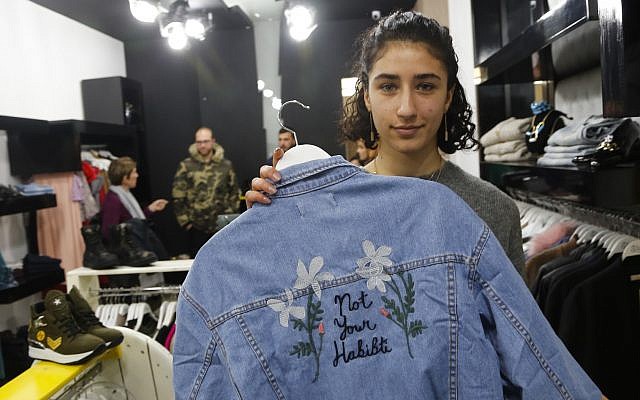 In this Wednesday, Jan. 24, 2018 photo, Palestinian-American Yasmeen Mjalli displays a jacket with the slogan 'Not Your Habibti (darling),' as a ready-made retort for cat calls, in the West Bank city of Ramallah. (AP Photo/Nasser Shiyoukhi)
