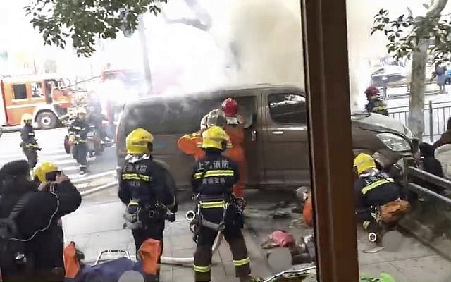 In this image taken from a cellphone video provided to the Associated Press, firefighters put out a blaze after a minivan carrying gas tanks plowed into pedestrians along a street in Shanghai, February 2, 2018. (AP) In this image taken from a cellphone video provided to the Associated Press, firefighters put out a blaze after a minivan carrying gas tanks plowed into pedestrians along a street in Shanghai, February 2, 2018. (AP)