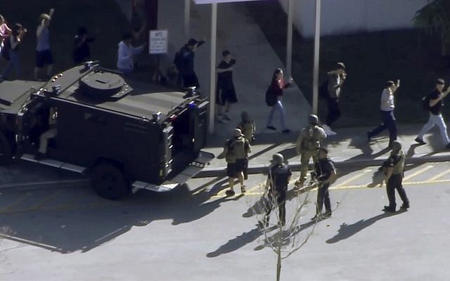 In this frame grab from video provided by WPLG-TV, students from the Marjory Stoneman Douglas High School in Parkland, Florida, evacuate the school following a shooting on February 14, 2018. (WPLG-TV via AP) In this frame grab from video provided by WPLG-TV, students from the Marjory Stoneman Douglas High School in Parkland, Florida, evacuate the school following a shooting on February 14, 2018. (WPLG-TV via AP)