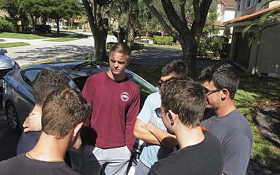 In this February 15, 2018 photo, John Greenberg, center, 17, talks with his friends outside his home in Parkland, Florida. Greenberg and his friends are juniors at Marjory Stoneman Douglas High School, where a former student shot and killed more than a dozen people on February 14. (AP Photo/Jason Dearen)