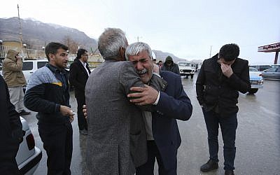 In this photo provided by Tasnim News Agency, family members of a feared plane crash victim weep in the village of Bideh, near the crash site, February 18, 2018.  (Ali Khodaei/Tasnim News Agency via AP)