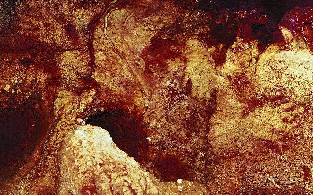 This color enhanced image provided by Hipolito Collado Giraldo in February 2018 shows three hand stencils in the Maltravieso Cave in Cáceres, Spain. (Hipolito Collado Giraldo via AP)
