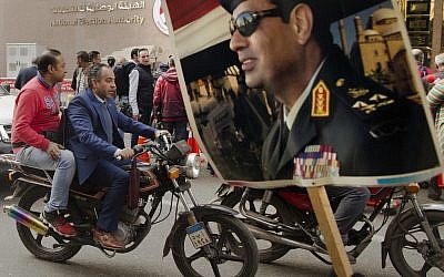 In this January 29, 2018 file photo, a supporter holds a poster showing Egyptian President Abdel-Fattah el-Sissi in front of the National Elections Authority in Cairo, Egypt. (AP Photo/Amr Nabil, File)