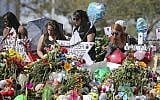 Mourners bring flowers as they pay tribute at a memorial for the victims of the shooting at Marjory Stoneman Douglas High School on February 25, 2018, in Parkland, Florida. (David Santiago/Miami Herald via AP)