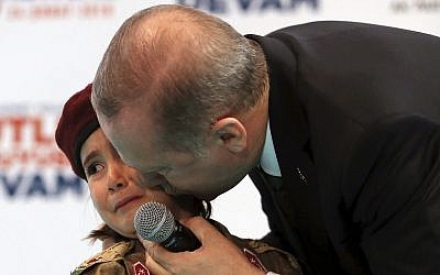 In this photo from February 24, 2018, Turkish President Recep Tayyip Erdogan kisses Amine Tiras, a young girl in military uniform as he speaks to his ruling party members, in Kahramanmaras, Turkey. (Murat Cetinmuhurdar/Pool Photo via AP, File)