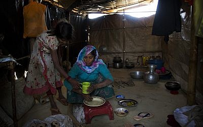 In this January 28, 2018 photo, Rohingya Muslim refugees Nooranksih, 9, left, and her mother Rohima Khatu, 45, originally from the Myanmar village of Gu Dar Pyin, eat inside their makeshift shelter at Balukhali refugee camp, Bangladesh. (AP/Manish Swarup)