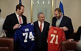 Jewish NFL football players and brothers Geoff (l) and Mitchell (r) Schwartz present Prime Minister Benjamin Netanyahu with football jerseys that have his nickname on them, in his Jerusalem office, on February 19, 2018. (Judah Ari Gross/Times of Israel)