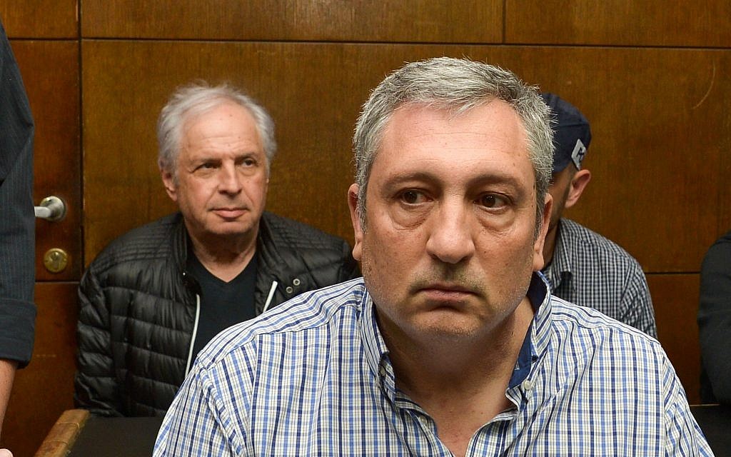 Prime Minister Benjamin Netanyahu's former spokesman Nir Hefetz (foreground) and Bezeq controlling shareholder Shaul Elovitch attend a remand hearing at the Tel Aviv Magistrate's Court, February 26, 2018. (Flash90)