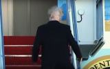 A powerful gust of wind musses Donald Trump's hair while he boards Air Force One in early February 2018. (Screen capture: YouTube)