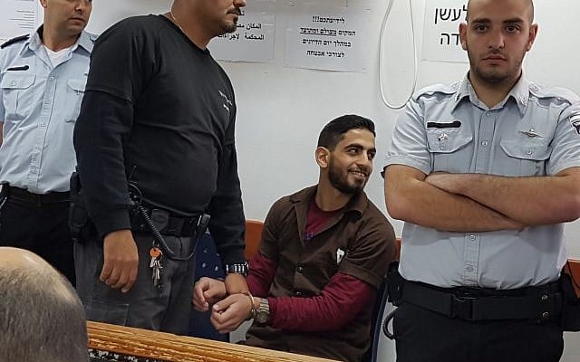 Omar al-Abed (c) smiles in the Judea Military Court ahead of his sentencing on February 15, 2018 for the murders of Yosef, Elad, and Chaya Salomon. (Courtesy) Omar al-Abed (c) smiles in the Judea Military Court ahead of his sentencing on February 15, 2018 for the murders of Yosef, Elad, and Chaya Salomon. (Courtesy)