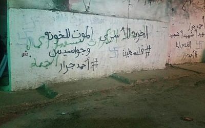 Swastikas and other graffiti spray painted on the outer wall of what some Jews believe to be the grave-site of biblical character Yehoshua Bin Nun in the Palestinian village of Kifl Haris, in the West Bank on February 22, 2016. (Courtesy: Samaria security)