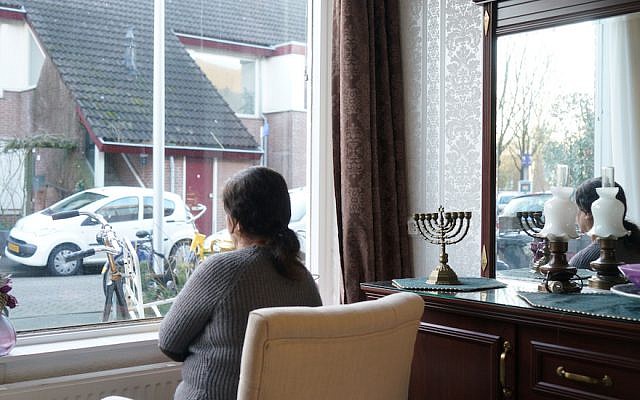 Sipora, a Jewish refugee from Iran, looking out the window of her daughter’s Netherlands home, Feb. 15, 2018. (Cnaan Liphshiz)