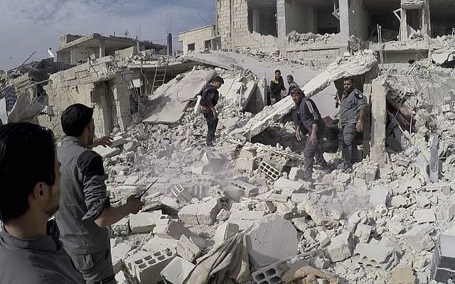 This photo provided by the Syrian Civil Defense White Helmets and authenticated, based on its contents and other AP reporting, shows civil defense workers and civilians inspecting a damaged building after airstrikes hit a rebel-held suburb near Damascus, Syria, on February 8, 2018. (Syrian Civil Defense White Helmets via AP) This photo provided by the Syrian Civil Defense White Helmets and authenticated, based on its contents and other AP reporting, shows civil defense workers and civilians inspecting a damaged building after airstrikes hit a rebel-held suburb near Damascus, Syria, on February 8, 2018. (Syrian Civil Defense White Helmets via AP)