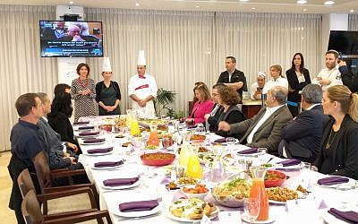 Knesset lawmakers tuck into vegan alternatives to their meat and dairy favorites in support of annual Animal Rights Day. Tamar Zandberg (Meretz), who hosted the feast, stands at the end of the table next to the chefs, February 6, 2018. (Anonymous for Animal Rights).